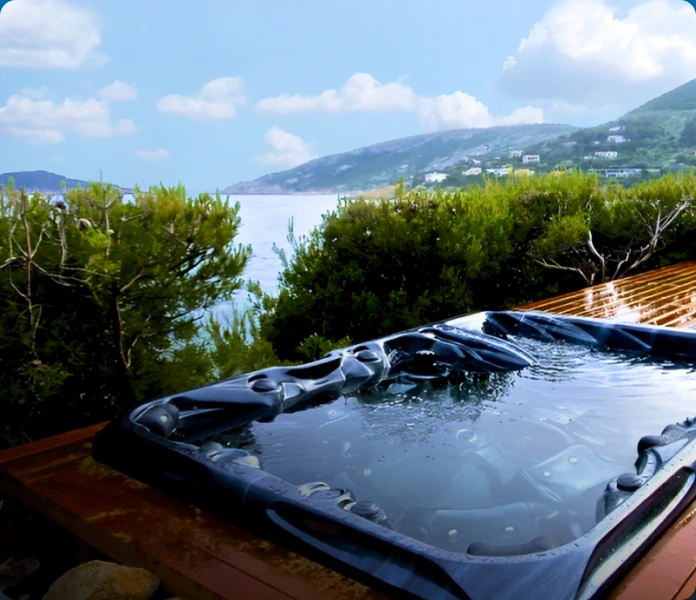 A hot tub on a wooden deck with a stunning view of the ocean.
