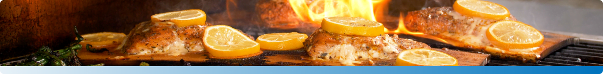 A grill filled with lemons and various foods.