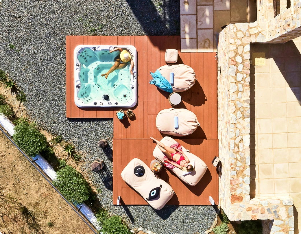 Bird's-eye view of a hot tub in an outdoor relaxation area with two women.